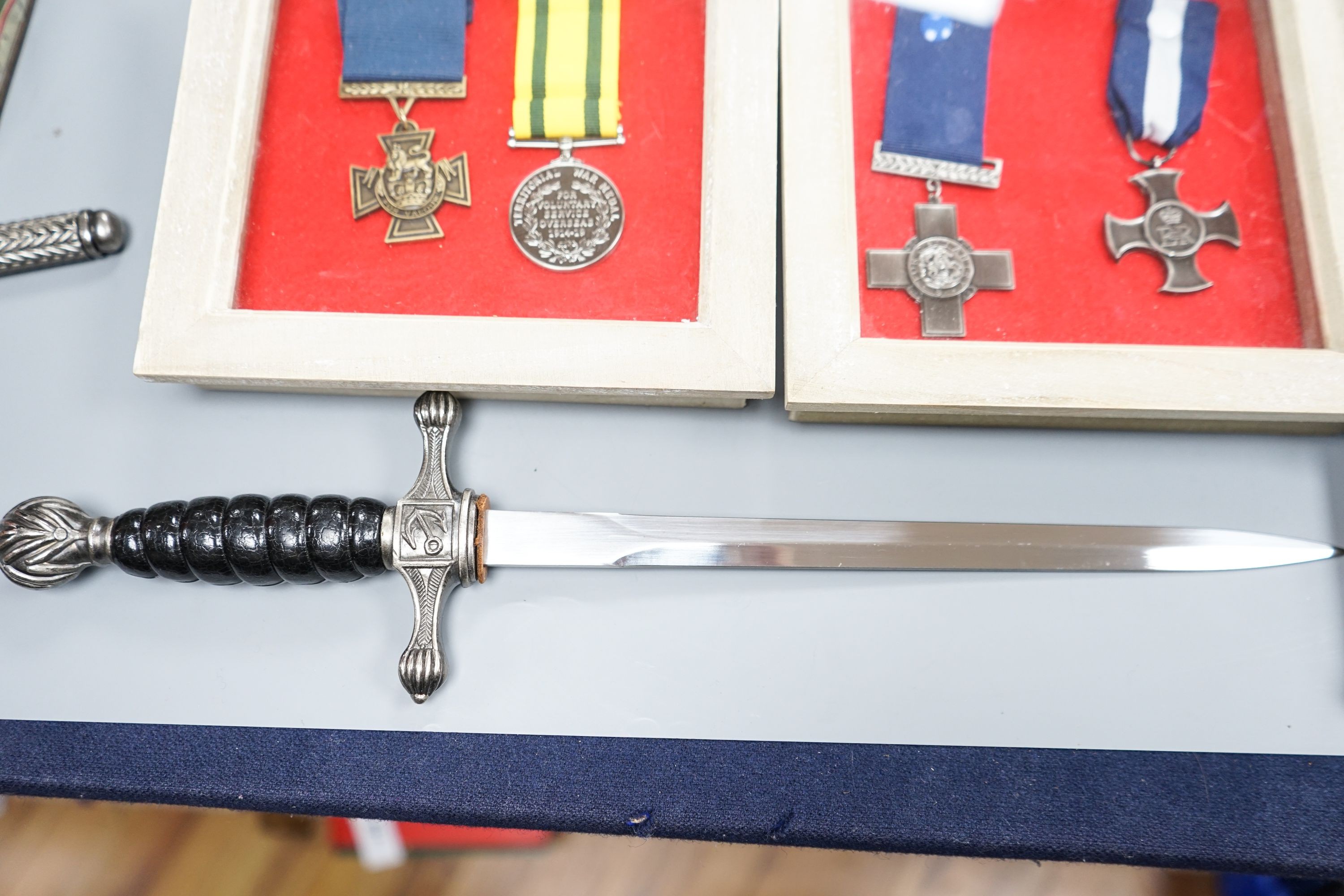 A Canadian First War Christie Brown and Co printed biscuit tin, framed medals, a trench art brass cigarette case and a reproduction German dagger.